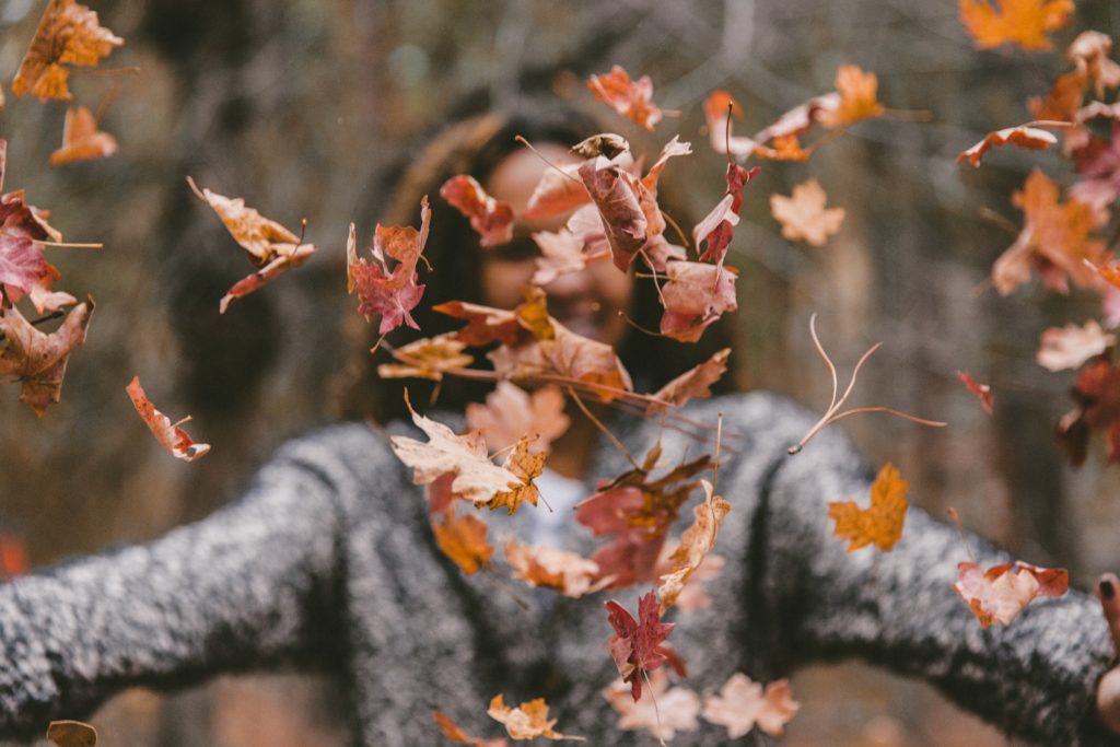 Mujer autocompasiva celebrando el otoño