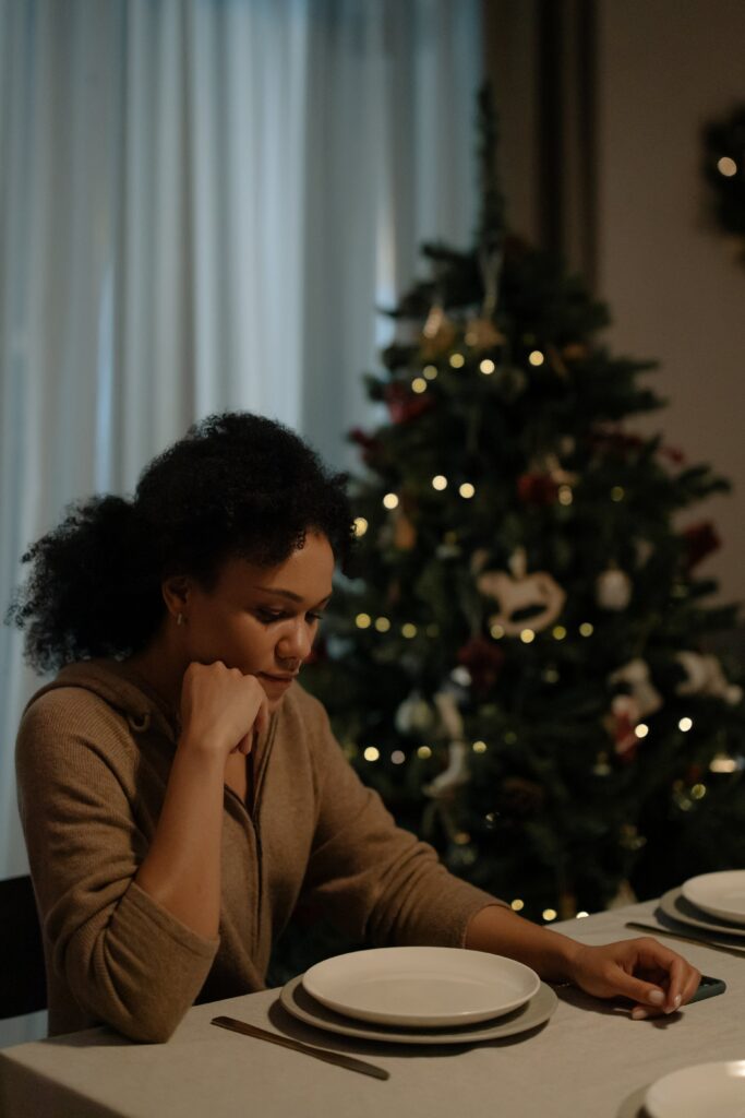 Mujer joven frente al plato en comida familiar de Navidad