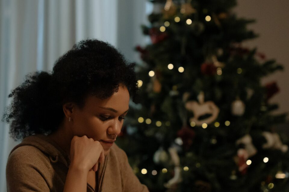 Mujer joven frente al plato en comida familiar de Navidad