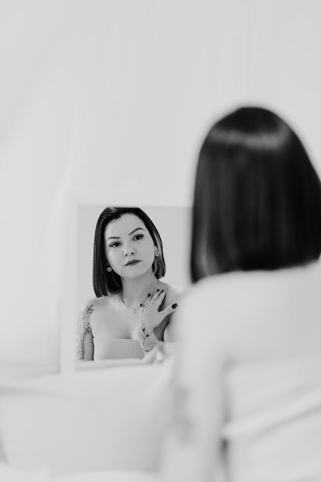 mujer se mira al espejo