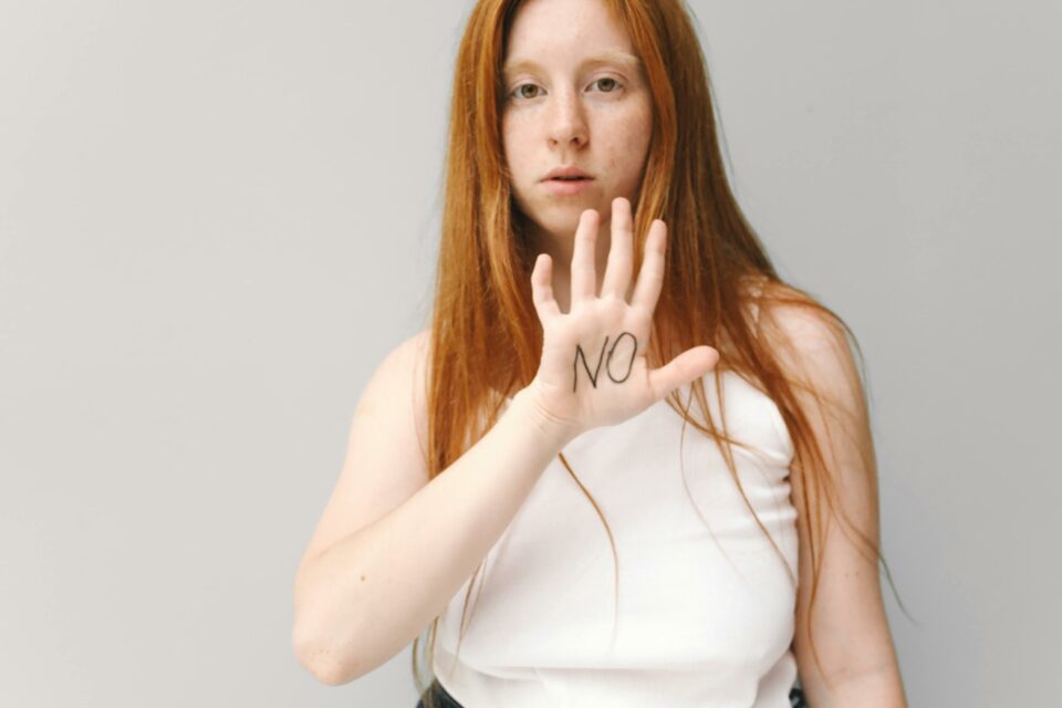 chica pelirroja pone la mano y dice no