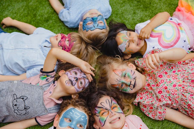 niños juegan pintura cara cesped