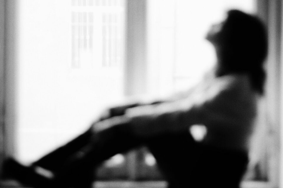mujer sentada mirando por la ventana en blanco y negro