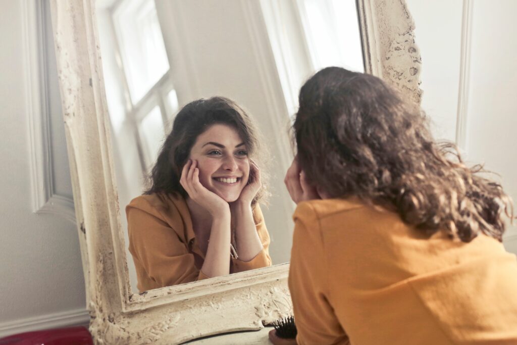 Mujer mirándose al espejo y sonriendo