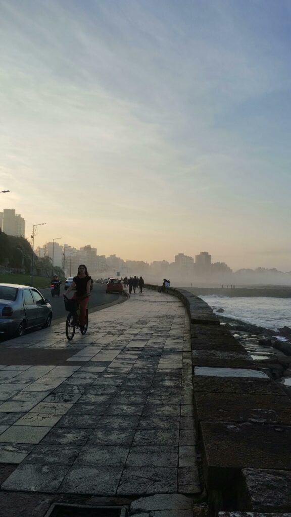 mujer montando en bici por paseo marítimo