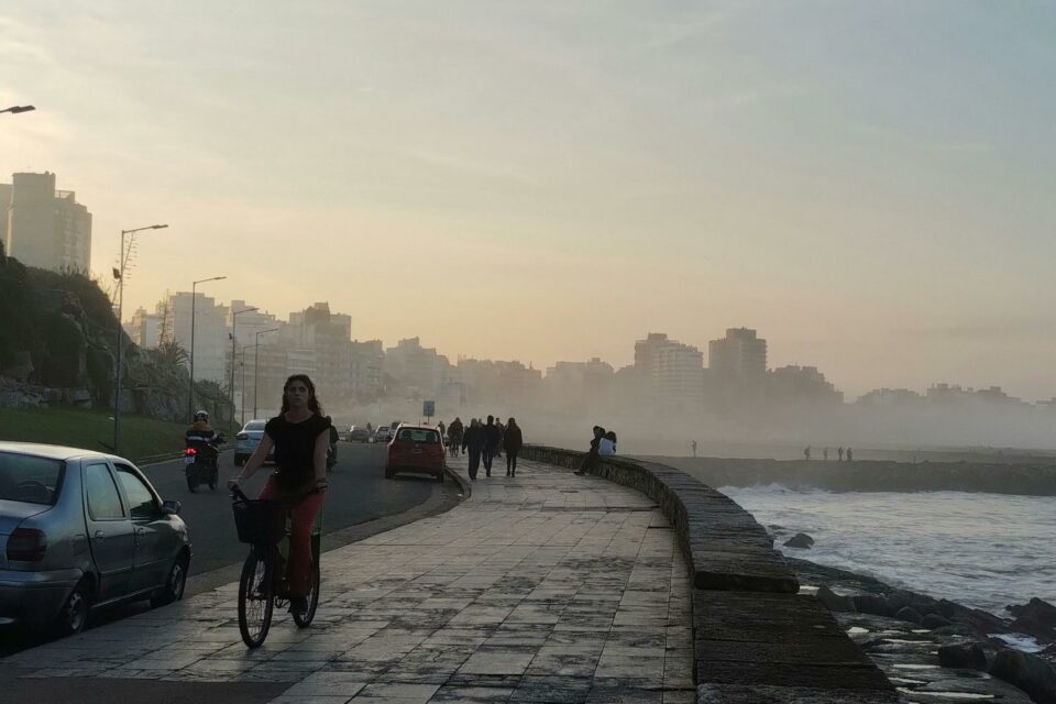 mujer montando en bici por paseo marítimo