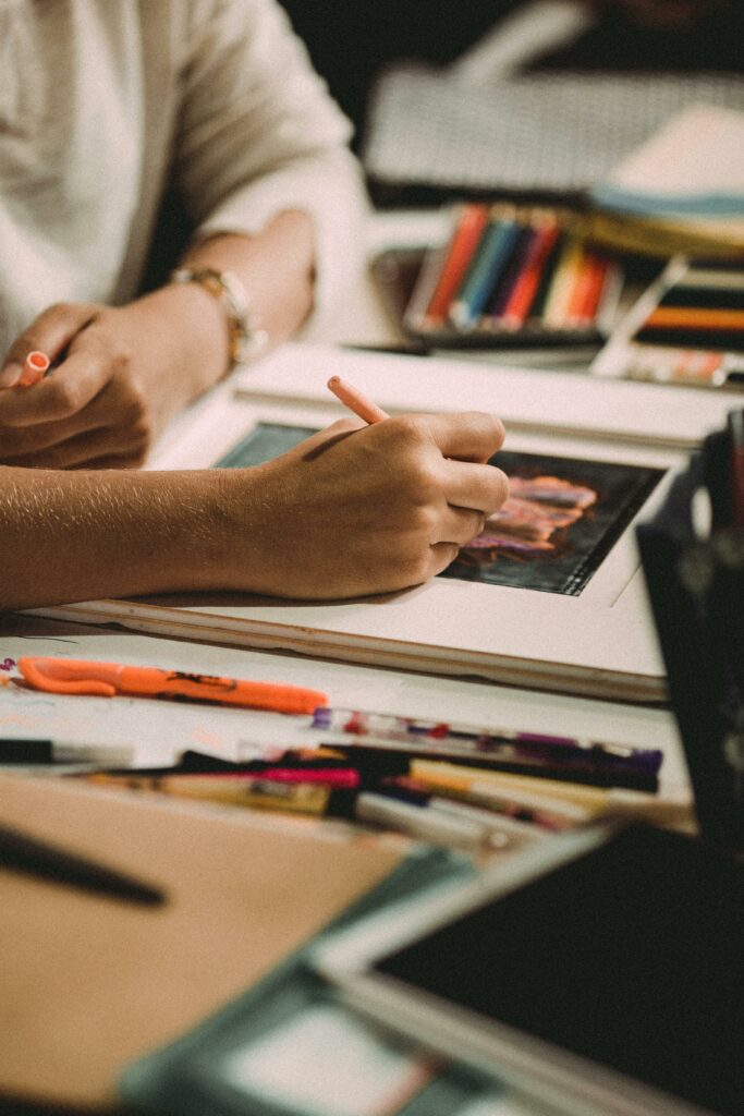 mujer pintando un dibujo con lápices de colores